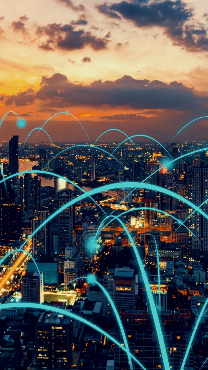 City Skyline at sunset with digital network connections representing smart city technology and connectivity.